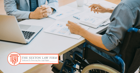 image of a person in a wheelchair talking to someone at a desk